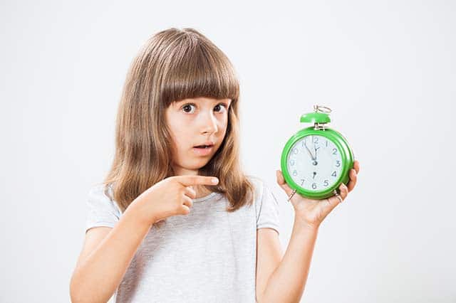 child holding a clock